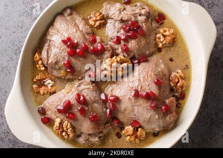 Fesenjan est un ragoût iranien simple, lentement cuit, avec des noix moulées, des mélasses de grenade et des cuisses de poulet en gros plan dans une casserole sur la table. Hori Banque D'Images