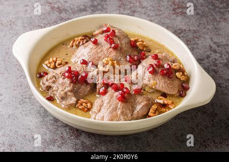 Fesenjan est un ragoût iranien simple, lentement cuit, avec des noix moulées, des mélasses de grenade et des cuisses de poulet en gros plan dans une casserole sur la table. Hori Banque D'Images