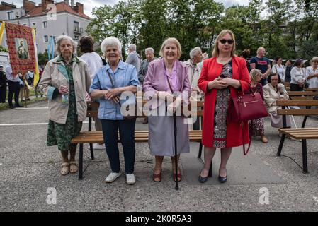 Les femmes attendent à l'extérieur de l'église pour que les masses commencent. Corpus Christi - célébration liturgique dans l'Église catholique en l'honneur de Jésus-Christ dans le Saint Sacrement. Une procession de croyants passa dans les rues de GDA?sk. Banque D'Images