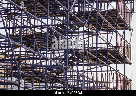 Échafaudage étendu fournissant des plates-formes pour les travaux en cours dans un nouveau bâtiment d'appartement, bâtiment de haute élévation en construction avec échafaudage Banque D'Images