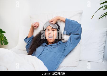 Une jeune femme multi-ethnique s'étire et nageait avec un masque de sommeil Banque D'Images