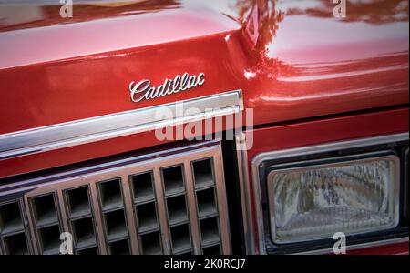 Emblème Cadillac au-dessus de la calandre de la voiture de luxe classique d'Amérique dans une peinture rouge vin à Lehnin, en Allemagne, en 11 septembre 2022 Banque D'Images