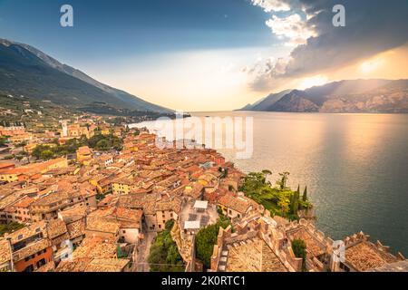 Au-dessus du lac de Garde idyllique avec des voiliers à Malcesine au coucher du soleil, alpes italiennes Banque D'Images