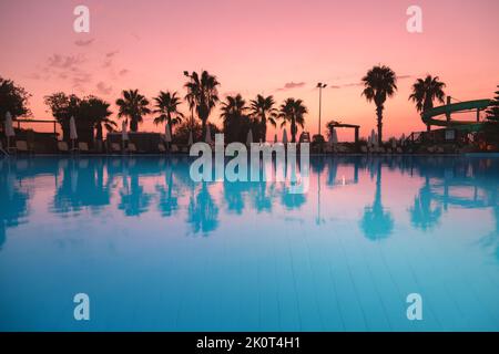 Belle réflexion dans la piscine au coucher du soleil coloré Banque D'Images