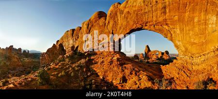 Panorama au lever du soleil de la fenêtre du Sud, à gauche, et de la fenêtre du Nord qui encadrent l'arche de la tourelle dans le parc national d'Arches, Moab, Utah. Banque D'Images