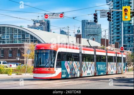 Un tramway ou un tramway Bombardier TTC moderne conduit dans la ville. Le véhicule a une publicité de public Mobile sur son côté. Banque D'Images