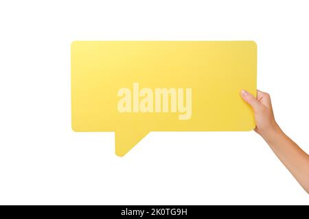 Gros plan de la main féminine tenant une grosse bulle de discours blanche jaune, présentez-la sur un mur blanc d'arrière-plan de studio avec un espace de copie pour la publicité Banque D'Images
