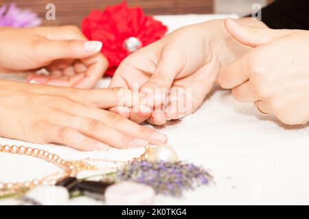 L'esthéticienne élimine l'ancien vernis à ongle avec un coton et de suppression Banque D'Images