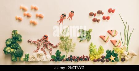 pieuvre, poissons, méduses, étoiles de mer à base de fruits rouges, tomate, kiwi, fraise dans le monde marin à partir de chou-fleur, brocoli et herbes vertes isolées o Banque D'Images