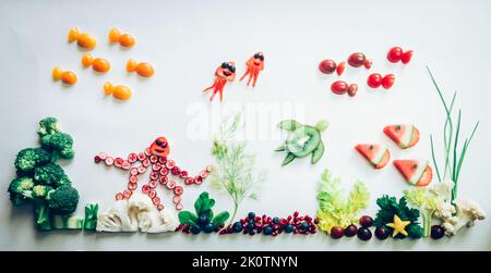 pieuvre, poissons, méduses, étoiles de mer à base de fruits rouges, tomate, kiwi, fraise dans le monde marin à partir de chou-fleur, brocoli et herbes vertes isolées o Banque D'Images