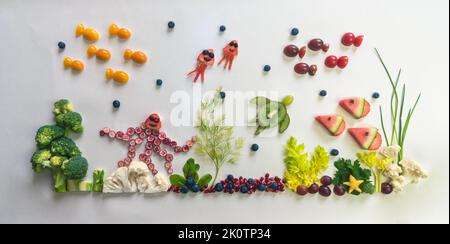 pieuvre, poissons, méduses, étoiles de mer à base de fruits rouges, tomate, kiwi, fraise dans le monde marin à partir de chou-fleur, brocoli et herbes vertes isolées o Banque D'Images