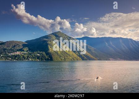 Montagne et bateau sur le lac de Côme près de Bellagio au coucher du soleil, Italie Banque D'Images