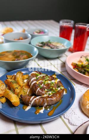 saucisses maison avec pommes de terre sur la table à manger avec différents plats Banque D'Images
