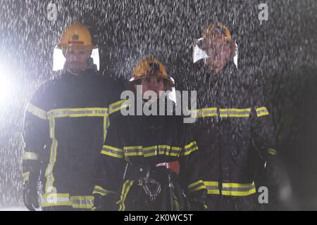 Portrait d'un groupe de pompiers debout et marchant courageux et optimiste avec une femme comme chef d'équipe. Banque D'Images