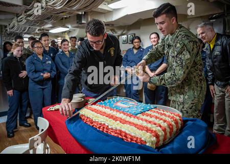 USS Arlington, États-Unis d'Amérique. 11 septembre 2022. Le lieutenant Christopher Gardner, de la Marine américaine, à gauche, et le marin Kai Sablan, ont coupé un gâteau de drapeau américain lors d'une cérémonie en 9/11 dans le pont en désordre du navire de transport amphibie USS Arlington, 11 septembre 2022, dans la mer Baltique. La nation a marqué le 21st anniversaire des attaques terroristes d'Al-Qaida qui ont tué près de 3 000 personnes. Crédit : MC1 John Bellino/US Navy photo/Alay Live News Banque D'Images