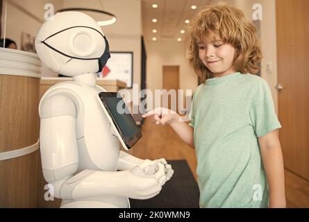 le garçon interagit avec l'intelligence artificielle de robot, la communication Banque D'Images