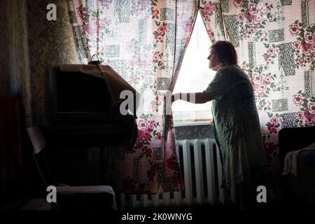 Bakhmut, Oblast de Donetsk, Ukraine. 18th août 2022. La résidante locale VALENTINA PAVILIVNA BONMARENKO, 79 ans, regarde sa fenêtre de la chambre de sa maison, à la périphérie est de Bakhmut. Les bombardements ont toujours été entendus alors que les forces ukrainiennes ont bloqué une tentative d'avancée dans la région par les troupes russes alors que la Russie bombarde la ville tous les jours. (Image de crédit : © Daniel Carde/ZUMA Press Wire) Banque D'Images