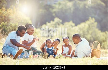 Famille noire, pique-nique nature et liens avec les enfants, les parents et les grands-parents dans les champs éloignés de campagne en été. Mère, père ou aîné avec Banque D'Images