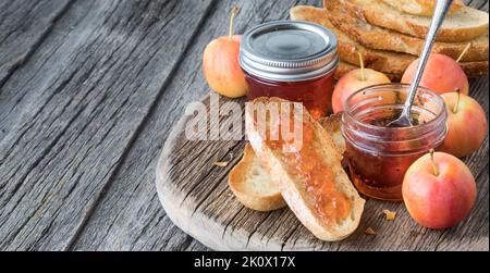 Un arrangement de toast et de gelée de pomme de crabe sur un tableau rustique avec espace de copie. Banque D'Images