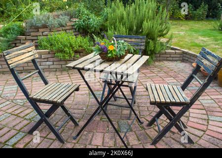 spirale d'herbes dans le jardin et table avec chaises Banque D'Images