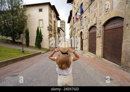 Vacances en Italie. Vue arrière de la belle fille de voyageur tenue chapeau aime visiter la ville historique d'Arezzo, Toscane, Italie. Banque D'Images