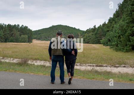 Couple debout sur la piste cyclable et regardant la colline. Banque D'Images