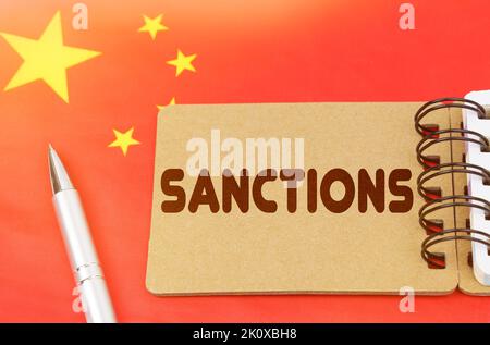 Concept d'économie nationale. Sur le drapeau de la Chine se trouve un carnet avec l'inscription - sanctions Banque D'Images