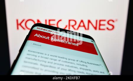 Téléphone mobile avec le site web de la société finlandaise de grue Konecranes Oyj sur l'écran devant le logo de l'entreprise. Faites la mise au point dans le coin supérieur gauche de l'écran du téléphone. Banque D'Images