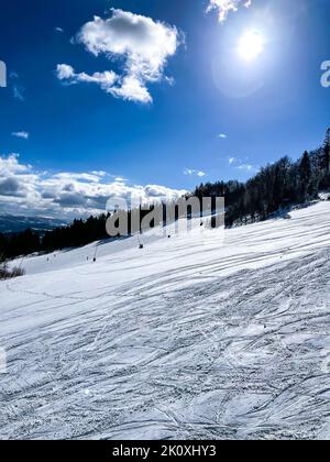 Skieurs ski alpin dans les montagnes de la station d'hiver. Vue aérienne du dessus du domaine skiable. Skieurs et snowboardeurs qui descendent la colline. Skieurs et remontées mécaniques dans la station de ski alpin des Carpates, majestueux paysage alpin d'hiver enneigé en Ukraine Banque D'Images