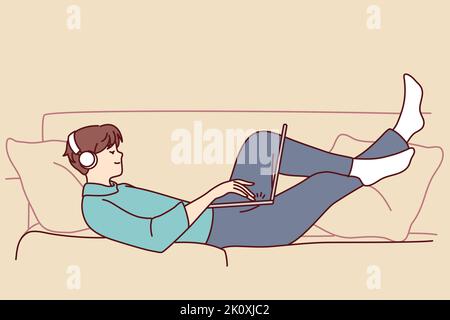 Un homme heureux allongé sur un canapé porte un casque qui fonctionne sur un ordinateur portable. Un homme souriant se détendre sur un canapé à la maison écouter de la musique dans des écouteurs à l'aide d'un ordinateur. Illustration vectorielle. Illustration de Vecteur
