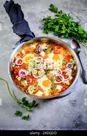 Shakshouka - oeufs pochés en sauce aux tomates, poivrons, oignons et feta. Repas de keto et faible carb. Banque D'Images