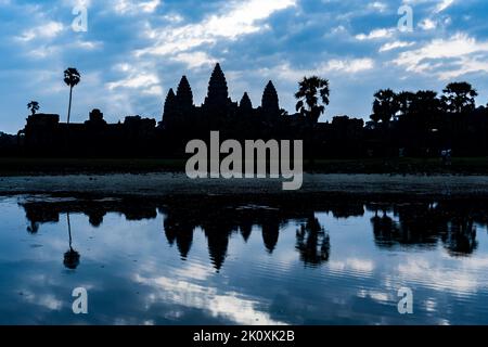 Cambodge. Province de Siem Reap. Une silhouette d'Angkor Wat (ville du Temple) et son reflet dans le lac en début de matinée. Un complexe bouddhiste et temple Banque D'Images