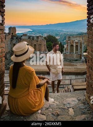 Couple hommes et femme visite les ruines du théâtre grec ancien à Taormina sur fond de volcan Etna, Italie. Taormina située dans la ville métropolitaine de Messine, sur la côte est de l'île de Sicile Italie Banque D'Images