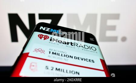 Smartphone avec le site Web de la société New Zealand Media and Entertainment (NZME) à l'écran devant le logo. Faites la mise au point dans le coin supérieur gauche de l'écran du téléphone. Banque D'Images