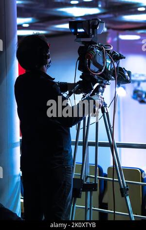 Caméraman professionnel couvrant un événement. Silhouette de l'opérateur de la caméra. Diffusion en direct à la télévision Banque D'Images