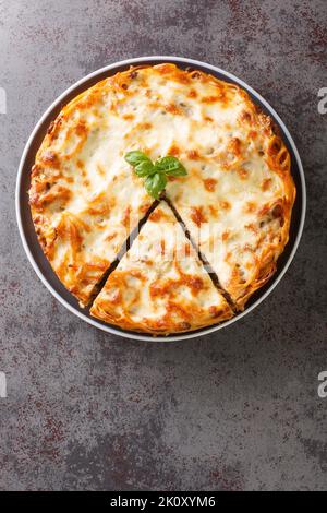 Tarte américaine aux pâtes spaghetti avec viande hachée, sauce tomate et fromage dans l'assiette sur la table. Vue verticale du dessus Banque D'Images