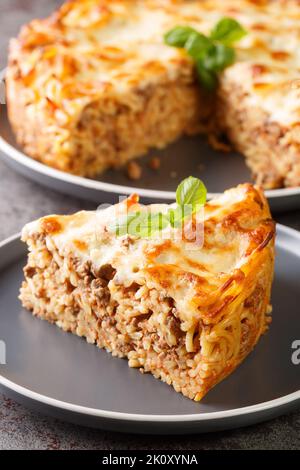 Tarte américaine aux pâtes spaghetti avec viande hachée, sauce tomate et fromage dans l'assiette sur la table. Verticale Banque D'Images