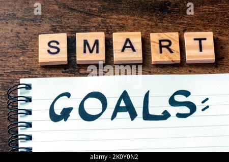 Concept Smart Goals. Le mot manuscrit dans un bloc-notes sur un bureau en bois. Rédaction d'un plan ou d'une liste Banque D'Images