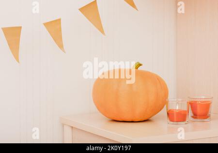 drapeaux de citrouille et d'orange. bougies brillantes avec parfum de citrouille. décoration d'intérieur pour halloween. récolte d'automne, décoration de saison Banque D'Images