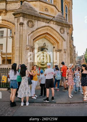 The Corpus Clock / Grasshopper horloge et les touristes d'été à l'extérieur de la bibliothèque Taylor, Cambridge Cambridgeshire Angleterre Royaume-Uni - tourisme Banque D'Images