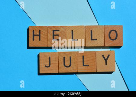 Bonjour juillet, mots en lettres de l'alphabet de bois isolées sur fond bleu Banque D'Images