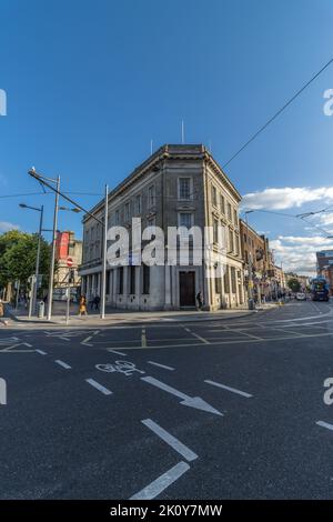 Une photo d'angle de l'ancienne branche de la banque AIB à partir du coin avec des panneaux de signalisation routière visibles sur l'asphalte, Dublin, Irlande. Banque D'Images