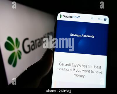 Personne tenant un téléphone portable avec le site web de la société turque de services financiers Garanti BBVA à l'écran avec logo. Concentrez-vous sur le centre de l'écran du téléphone. Banque D'Images