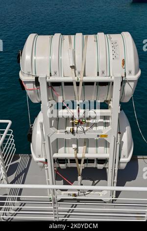 Athènes, Grèce - mai 2022 : conteneurs contenant des radeaux de sauvetage gonflables d'urgence stockés sur le côté d'un ferry. Banque D'Images