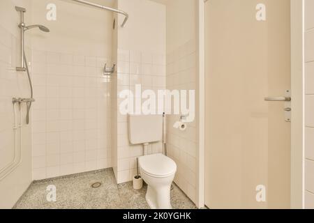 Toilettes et douche à chasse d'eau situées près de l'évier et de la machine à laver dans les toilettes à la maison Banque D'Images