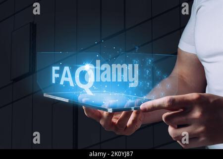 Concept de questions et réponses ou FAQ. Un affichage holographique avec des icônes est tenu par une personne Banque D'Images