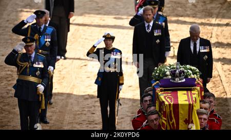 (De gauche à droite) le roi Charles III, le prince de Galles, et la princesse royale saluent, tandis que le duc de Sussex et le duc de York s'inclinent la tête, tandis que le parti Bearer de la Compagnie de la Reine, 1st gardes du bataillon Grenadier portent le cercueil de la reine Elizabeth II, Drapé dans la norme royale avec la couronne d'État impériale placée sur le dessus, dans Westminster Hall, Londres, où il sera dans l'état avant ses funérailles lundi. Date de la photo: Mercredi 14 septembre 2022. Banque D'Images