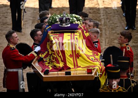 Le Bearer Party de la Queen's Company, 1st Battalion Grenadier Guards, porte le cercueil de la reine Elizabeth II, drapé dans le Royal Standard avec la Couronne impériale placée au-dessus, dans Westminster Hall, Londres, où il sera dans l'état avant ses funérailles lundi. Date de la photo: Mercredi 14 septembre 2022. Banque D'Images