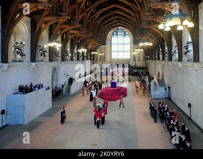 Le Bearer Party de la Compagnie de la Reine, le 1st Bataillon Grenadier Guards, transporte le cercueil de la reine Elizabeth II dans le Westminster Hall, Londres, où il sera dans l'état avant ses funérailles lundi. Date de la photo: Mercredi 14 septembre 2022. Banque D'Images