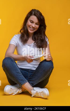 Femme assise à pieds croisés sur le sol avec la lettre Banque D'Images